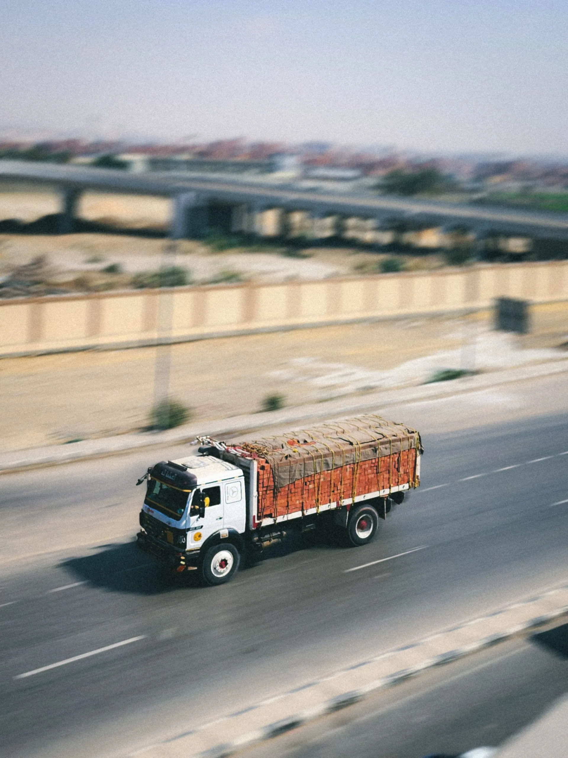 Laden freight truck in motion on a highway, representing door-to-door road logistics