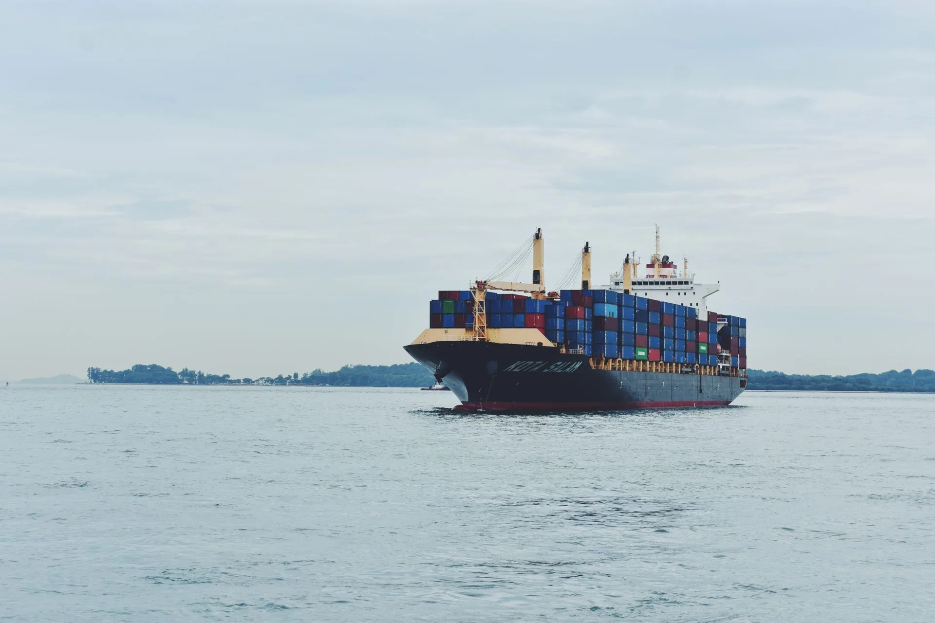 Large container ship loaded with cargo sailing across the ocean
